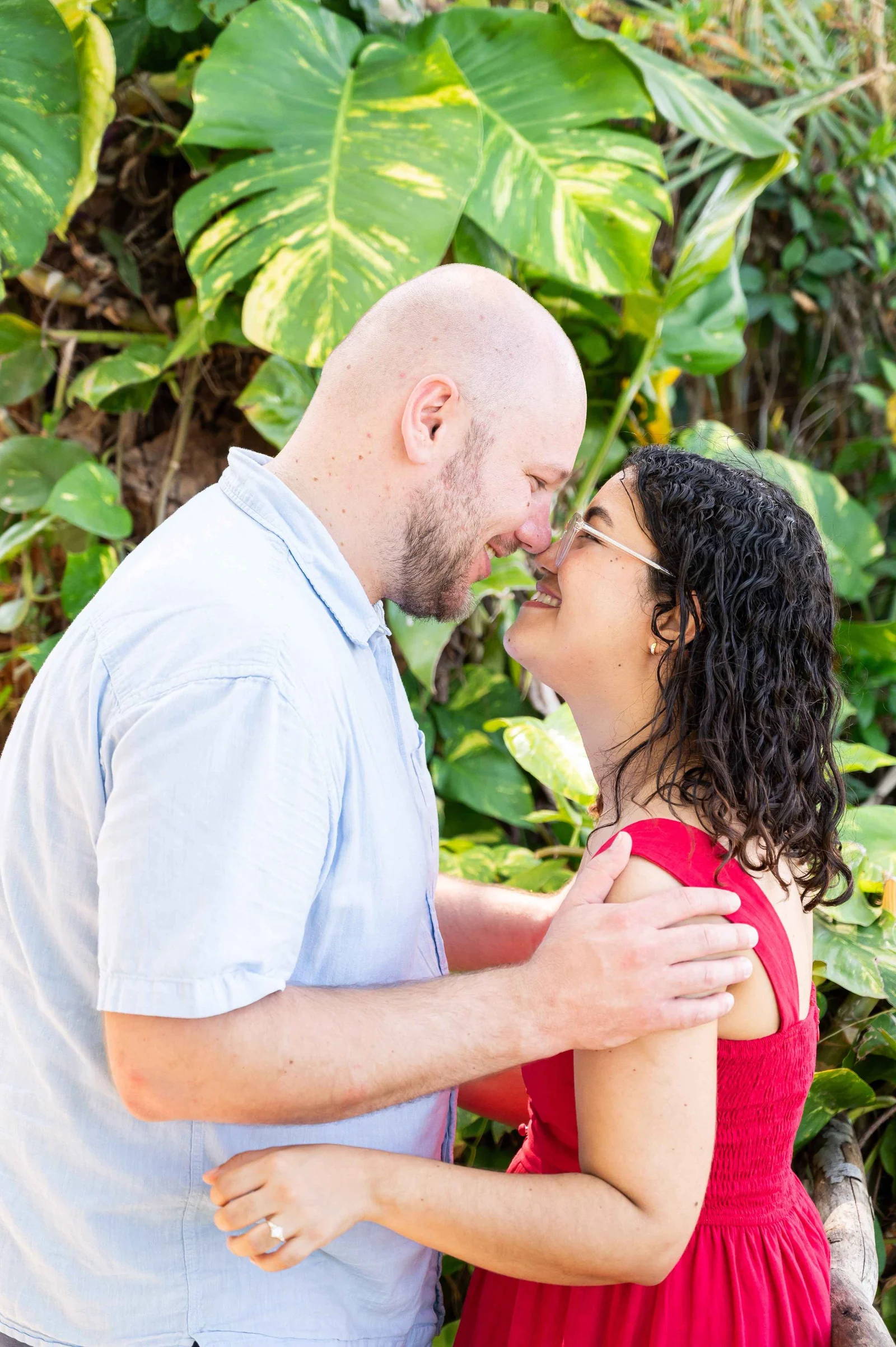 Philip and Niolvi smiling nose to nose among tropical leaves